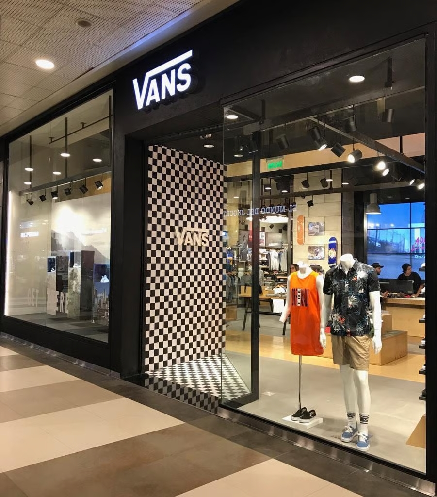 Fachada de local Vans Argentina en shopping, con logotipo iluminado y vidriera de zapatillas clásicas.